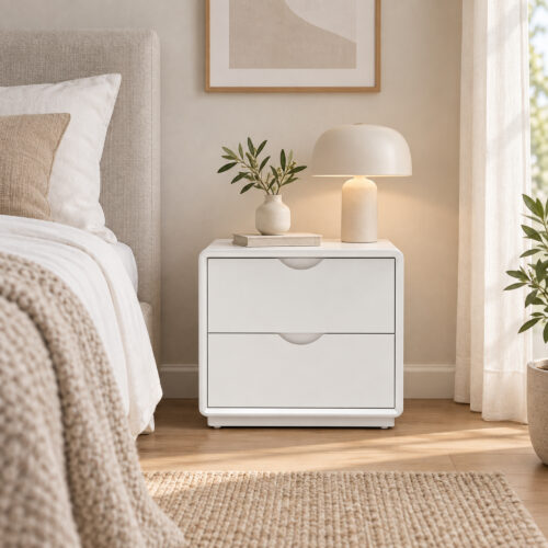 Arc White Two-Drawer Bedside Table with Recessed Pulls — front view beside a bed