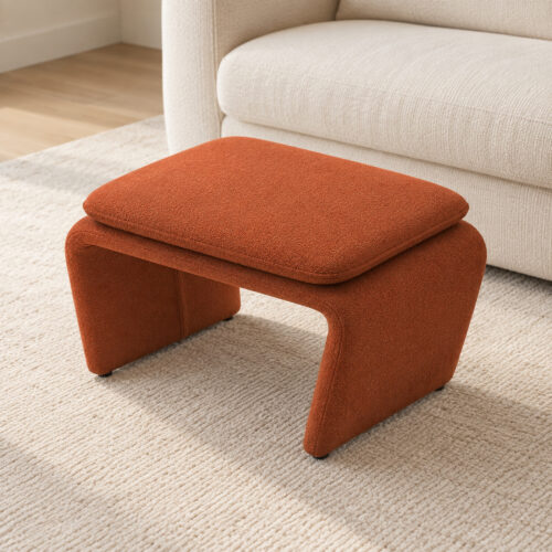 Rylan Camel Fabric Footstool with Curved Upholstered Supports — elevated view beside a cream sofa